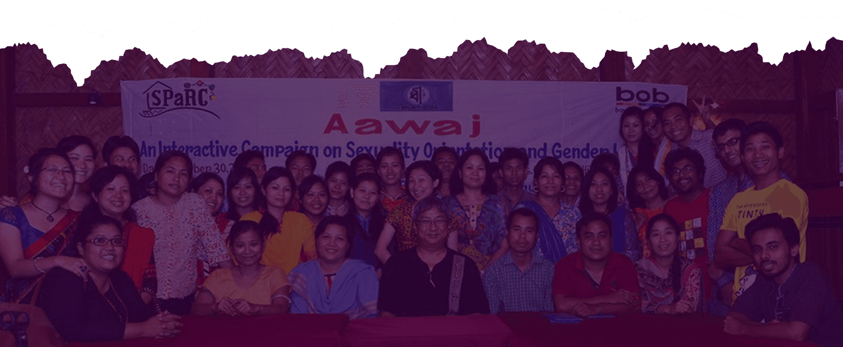Members of the SPaRC team and community gathered beneath an Aawaj campaign banner on sexuality and gender, Rangamati.